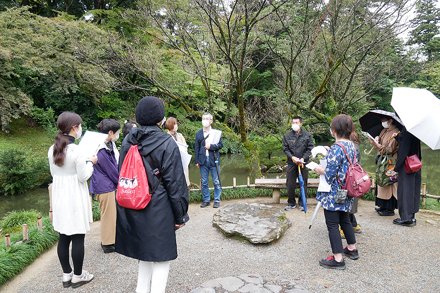 村瀬社長＝右から5人目＝の案内で兼六園を散策する様子